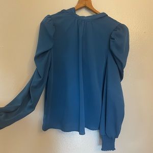 Like new Beautiful blouse, high neck, cuffed at the wrist, tie at the neck;